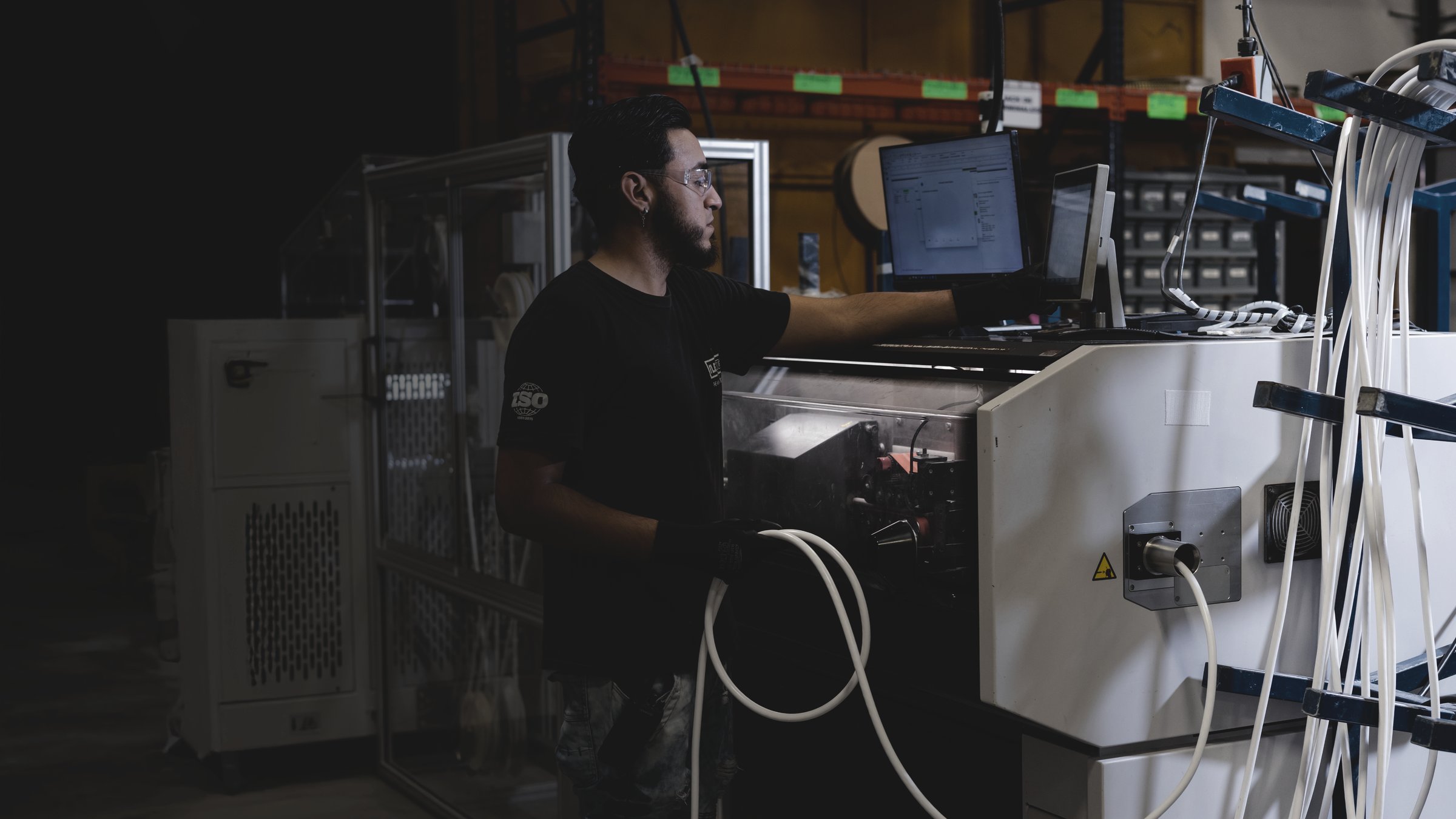 An ECI operator running a wire-processing machine on the production floor
